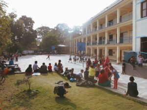 A lively scene of children playing and socializing in a sunny school courtyard, creating a vibrant atmosphere.
