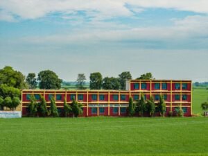 Colorful school building amidst lush green fields in Ludhiana, Punjab, India.